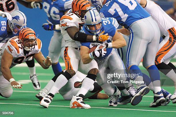 Cory Schlesinger of the Detroit Lions tries to break away from Takeo Spikes of the Cincinnati Bengals from during the game at the Pontiac Silverdome...