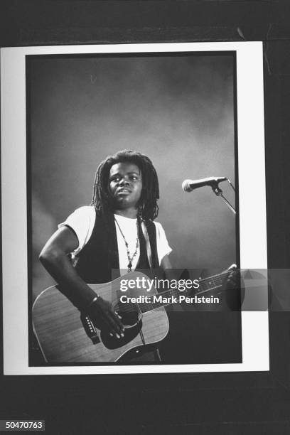 Singer Tracy Chapman playing guitar & singing on stage at Farm Aid V concert at Texas Stadium.