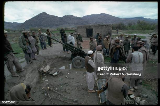 Ethnic Pathan mujahedin , based in Salafiya rebel faction-controlled Kunar province, outside bunker, w. Arsenal incl. Field gun.