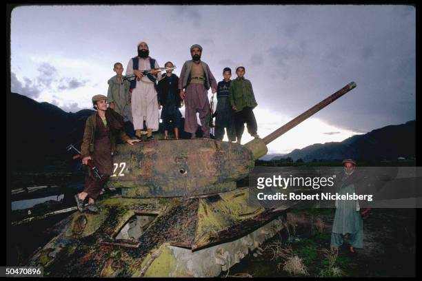 Ethnic Pathan mujahedin based in Salafiya rebel-controlled Kunar province, poised atop old Afghan tank fr. King Zahir Shah period.