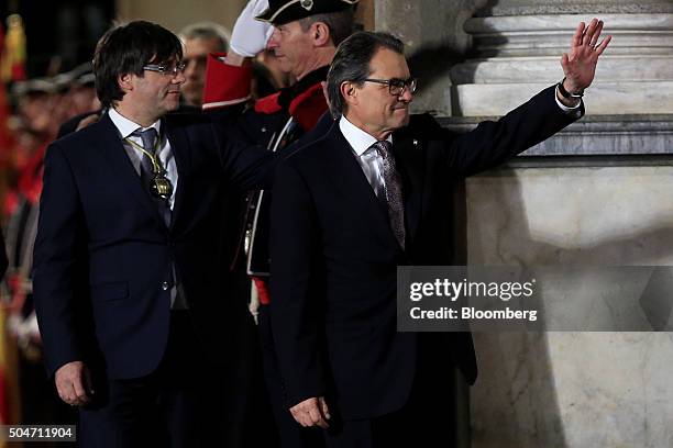 Carles Puigdemont, Catalonia's incoming president, left, and Artur Mas, former Catalan acting president, wave as they leave the Palau de la...