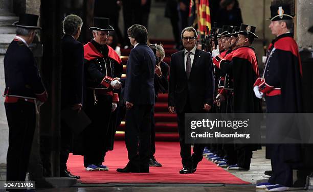 Carles Puigdemont, Catalonia's incoming president, left, greets the head of the honor of Catalan autonomous police, known as Mossos de Esquadra,...