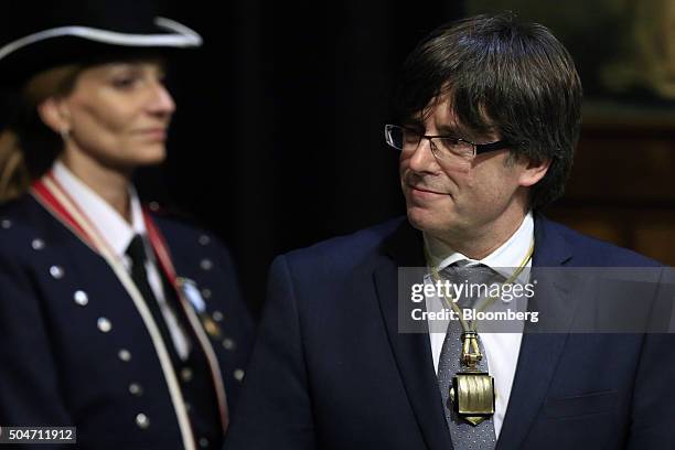 Carles Puigdemont, Catalonia's incoming president, smiles after he is sworn into office at the Palau de la Generalitat in Barcelona, Spain, on...