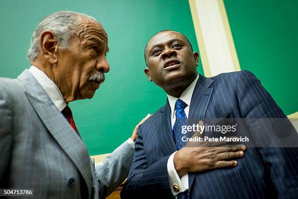 Rep. John Conyers greets forensic pathologist and neuropathologist, Dr. Bennet Omalu before a briefing sponsored by Rep. Jackie Speier on Capitol...