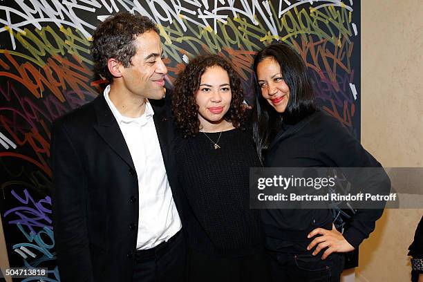 Artist JonOne, his wife Mai Lucas Perello and their daughter Jaika pose in front of a work JonOne has just realized in Live during the Guerlain...