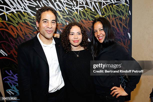 Artist JonOne, his wife Mai Lucas Perello and their daughter Jaika pose in front of a work JonOne has just realized in Live during the Guerlain...