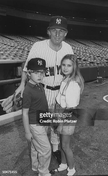 Real estate mogul Donald Trump wearing a Yankee baseball uniform w. Children Eric and Ivanka at a Police Atletic League softball game held at Yankee...