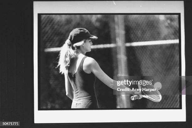 Tennis player Carling Bassett-Seguso making a blocking backhand stroke w. Tennis racquet at ball during practice session.