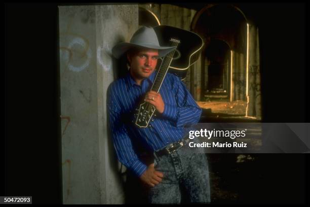 Singer Garth Brooks w. Guitar slung over shoulder.