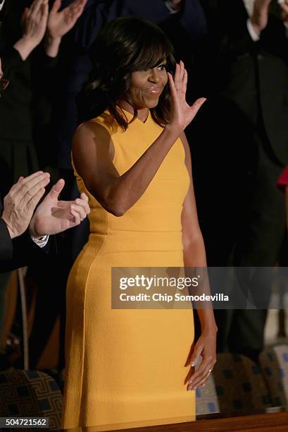 First lady Michelle Obama waves to members of congress before US President Barack Obama delivers the State of the Union speech before members of...