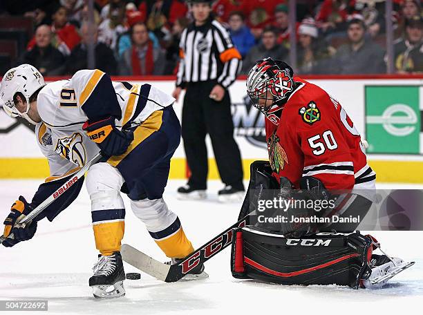 Corey Crawford of the Chicago Blackhawks knocks the puck back through the legs of Calle Jarnkrok of the Nashville Predators at the United Center on...