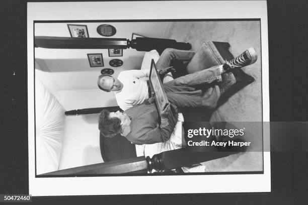 James Carville, pol. Consultant for Dem. Pres. Cand. Bill Clinton, going over photos w. His mom Lucille as they sit on four-poster bed at her home.