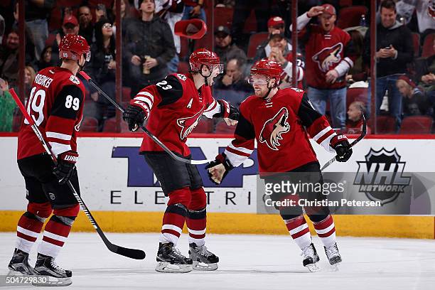 Max Domi of the Arizona Coyotes celebrates with Oliver Ekman-Larsson and Mikkel Boedker after Domi scored a hat trick goal against the Edmonton...