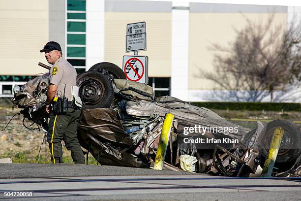 San Bernardino County Sheriff's deputies investigate mangles remains of a car along train tracks after a fatal collision with a East bound MetroLink...