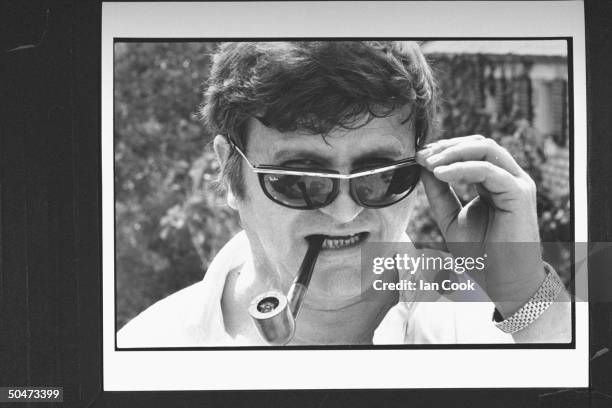 Yugoslavian chess promotor Jezdimir Vasiljevic w. Pipe in his mouth as he mysteriously peeks over the top of his fashionable Ray Ban sunglasses on...