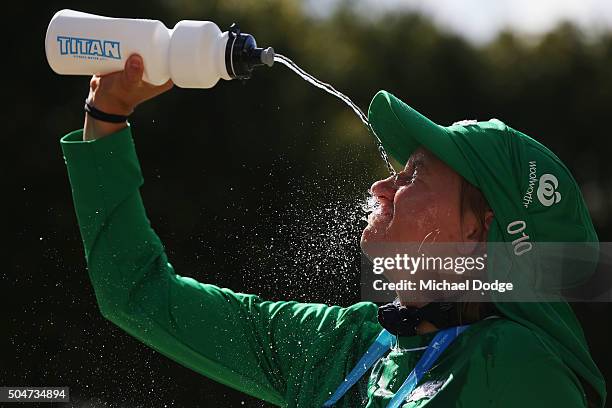 Ballgirl keeps herself cool while play is suspended due to the heat policy during 2016 Australian Open Qualifying at Melbourne Park on January 13,...