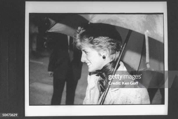 Princess Diana clad in double-breasted wool suit, carrying an open umbrella, during her walking tour in the rain. North England.