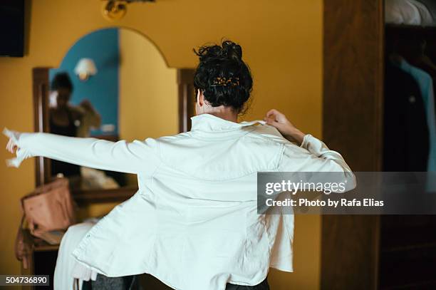 woman putting on shirt in bedroom - calçada imagens e fotografias de stock