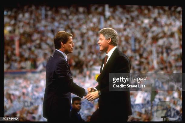 Bill Clinton & Al Gore clasping hands in face-to-face interaction on floor of Democratic Convention at Madison Square Garden.