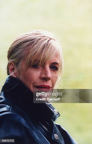 Singer Marianne Faithfull wearing black leather jacket as she poses outside her 19th C. Cottage.