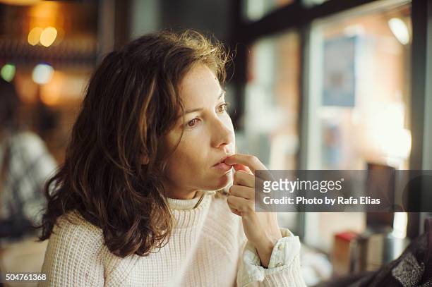 thoughtful woman in bar - confuso imagens e fotografias de stock