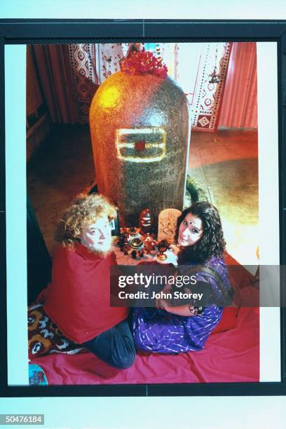 Michael Bowen, aka Baba Kali Das, & wife Isabella Paoli sitting in lotus position in front of the Shiva lingam, or sacred phallic symbol, a large...