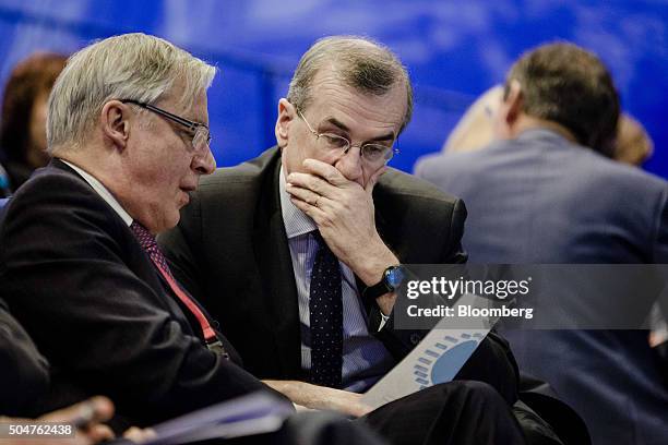 Christian Noyer, former governor of the Bank of France, left, looks at a document with Francois Villeroy de Galhau, governor of the Bank of France,...