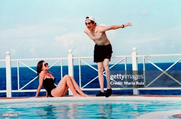 Actress Harlee McBride watching actor/husband Richard Belzer dive into swimming pool of Trident Villas & Hotel.