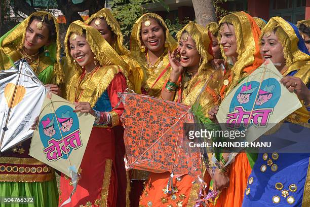 Indian college women clad in traditional Punjabi dress hold kites during celebrations on the occasion of the Lohri festival in Amritsar on January...