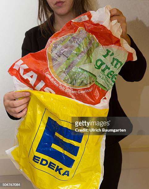 Takeover - Edeka swallows Tengelmann-Kaiser's. Kaiser's grocery bag is plugged into a Edeka bag.