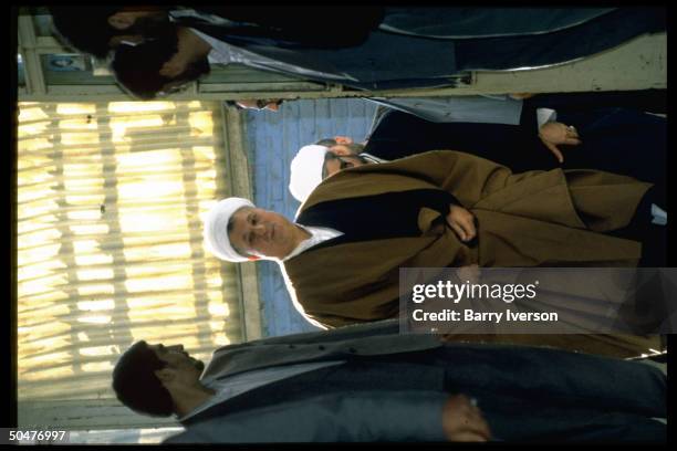 Pres. Ali Akbar Hashimi Rafsanjani at mosque elections polling station, coming to vote, entourage-in-tow.