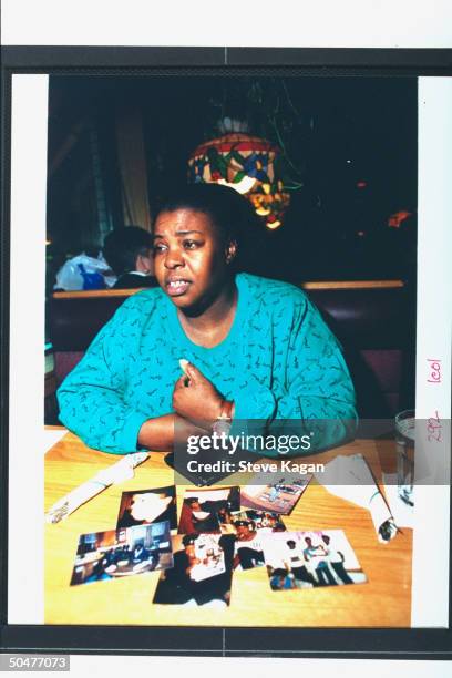 Theresa Smith, sister to serial killer Jeffrey Dahmer's murder victim Eddie Smith, sitting w. Pics of bro. On table in unident. Restaurant.