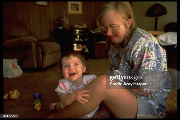 Down syndrome sufferer/activist Sandra Jensen, who has been refused heart & lung transplant because of her low IQ, playing w. Niece Shanna on floor...