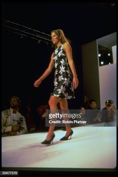 Actress Maxine Bahns strolling the catwalk in a black, sleeveless, floral-print, thigh-length dress by designer Nicole Miller at the NYC spring...