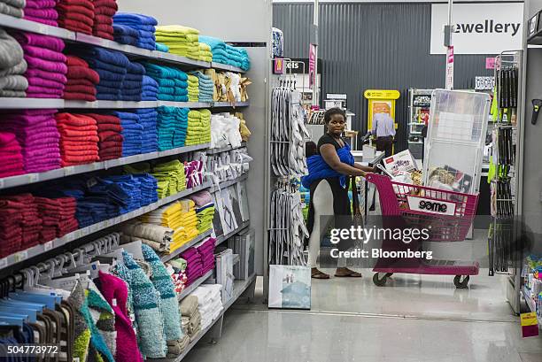Shopper pushes a shopping cart loaded with goods past a shopping aisle inside a Game supermarket, operated by Massmart Holdings Ltd., at the...