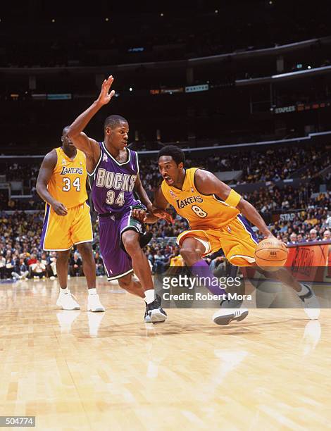 Small guard Kobe Bryant of the Los Angeles Lakers dribbles by small guard Ray Allen of the Milwaukee Bucks during the NBA game at the the Staples...
