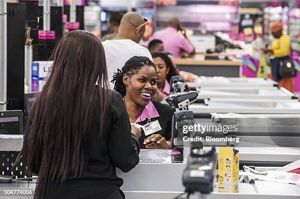 An employee reacts while serving a customer on the check out desk of a Game supermarket, operated by Massmart Holdings Ltd., at the Centurion Mall in...