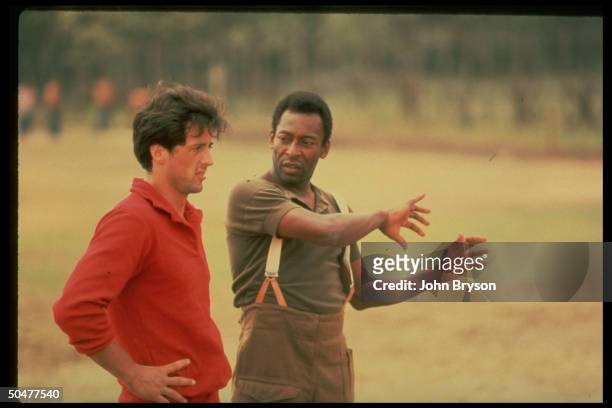 Actor Sylvester Stallone getting pointers fr. Soccer great Pele during filming of motion picture Escape to Victory.
