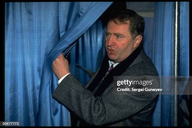 Ultra-nationalist Liberal Democrats ldr. Vladimir Zhirinovsky emerging fr. Voting booth during 1st democratic parliamentary elections.