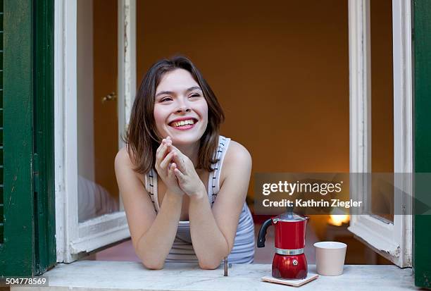 young woman having coffee at the open window - bricco per il caffè foto e immagini stock