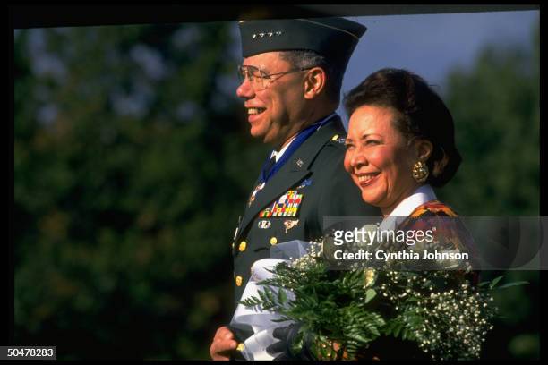 Outgoing Joint Chiefs Chmn. Gen. Colin Powell during his Fort Meyer farewell fete, w. Bouquet-holding wife Alma by his side.
