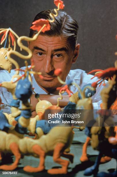 Children's book author/illustrator Theodor Seuss Geisel posing with models of characters he has created.