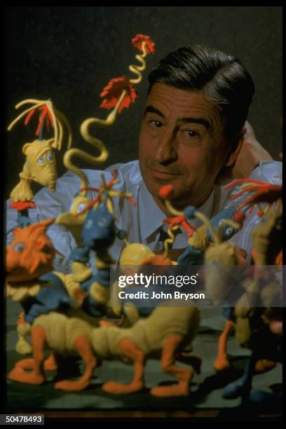 Children's book author/illustrator Theodor Seuss Geisel posing with models of characters he has created.