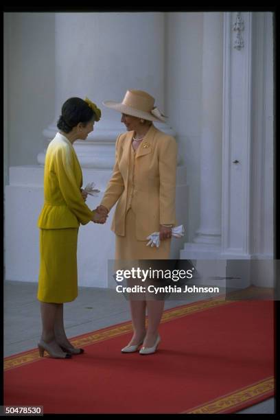 First Lady Hillary Rodham Clinton shaking hands with Empress Michiko of Japan , on red carpet during White House north portico departure.