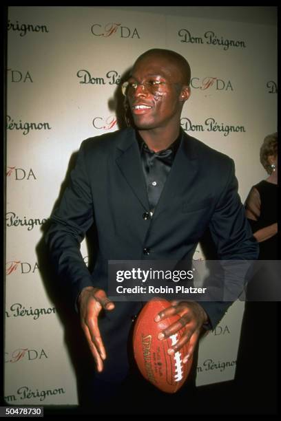 Pop singer Seal posing w. Football at 15th Annual Council of Fashion Designers of Amer. Awards.