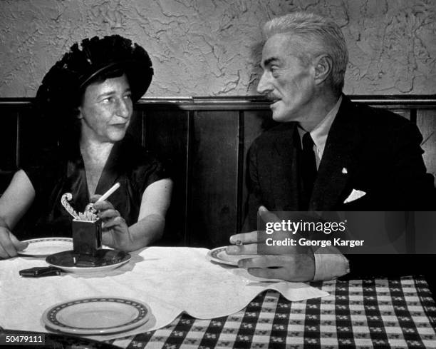 Author Dashiell Hammett & writer lover Lillian Hellman chatting at table at 21 Club.