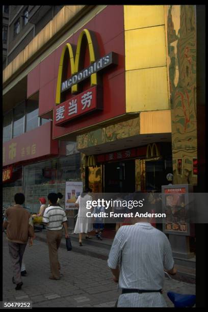 Locals entering McDonalds, outlet of US-based fast food chain, mark of growing Amer. Influence on Chinese culture.