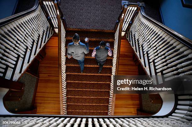 Visitors Landen Jones, left, and Joshua Potter, who are staying at the hotel for the week, walk up the grand staircase in the Stanley Hotel on...
