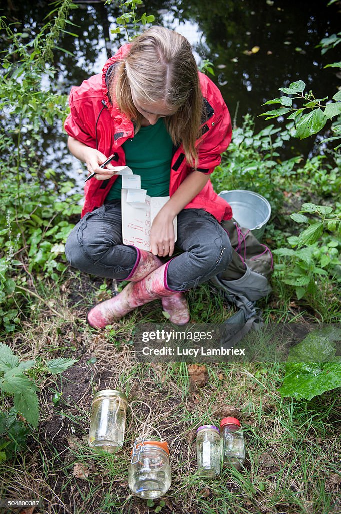 Young woman doing research by the side of a ditch