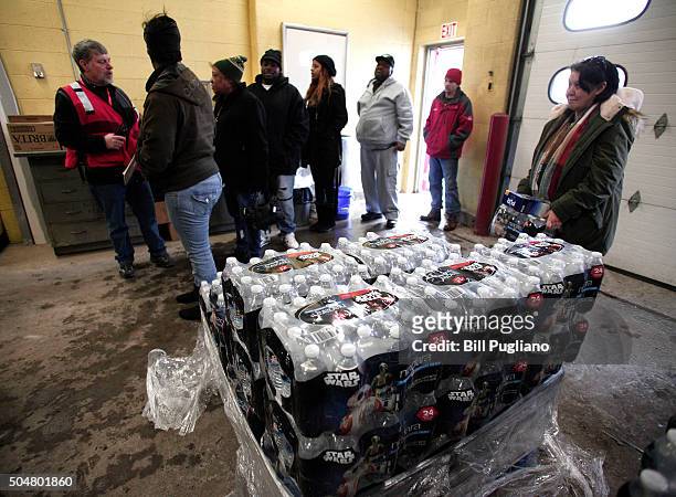 Flint residents line up to get bottled water, water testing kits, and water filters at a Flint Fire Station January 13, 2016 in Flint, Michigan. On...
